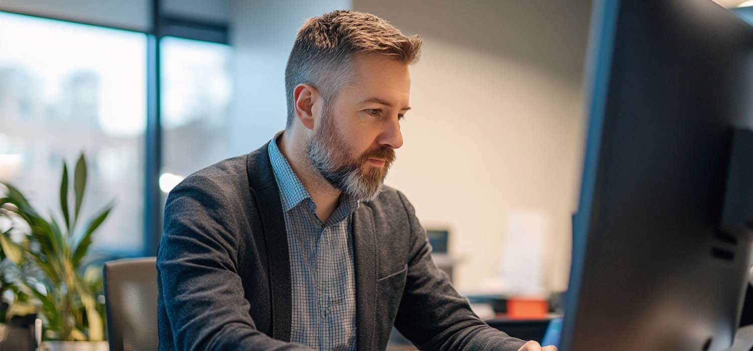 IT auditor assessing network security and technology systems in an office.