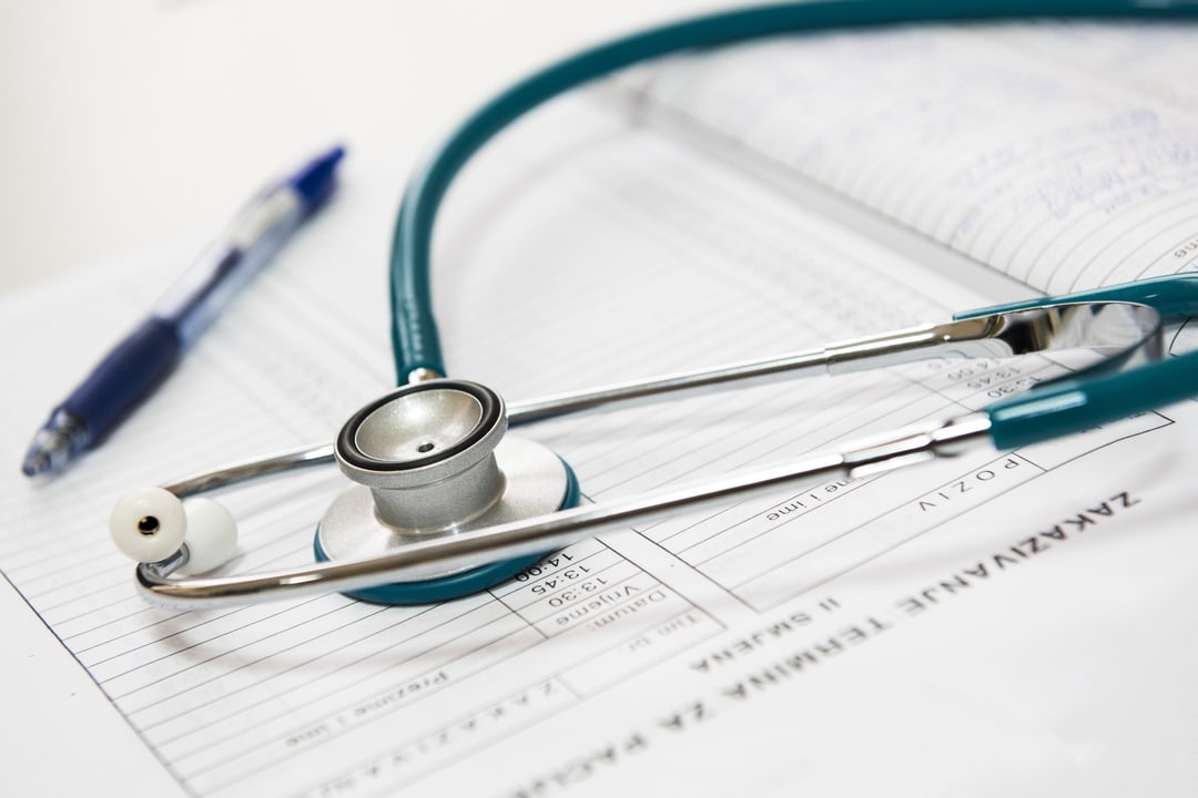 A sethoscope placed on a book depicting the healthcard industry