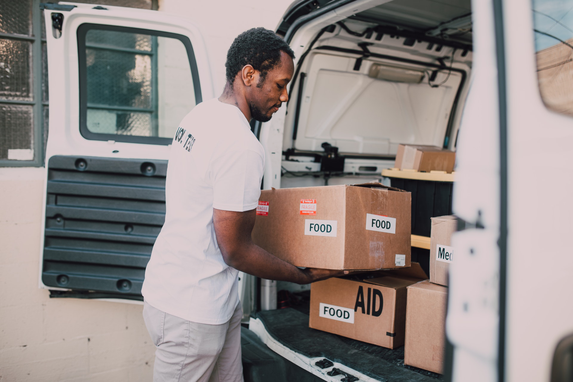 An NGO volunteer loading a van